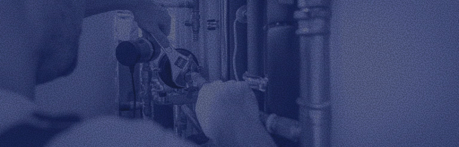 A finished basement utility room with large HVAC ductwork and boiler/plumbing equipment along the left and back walls, with no people visible.